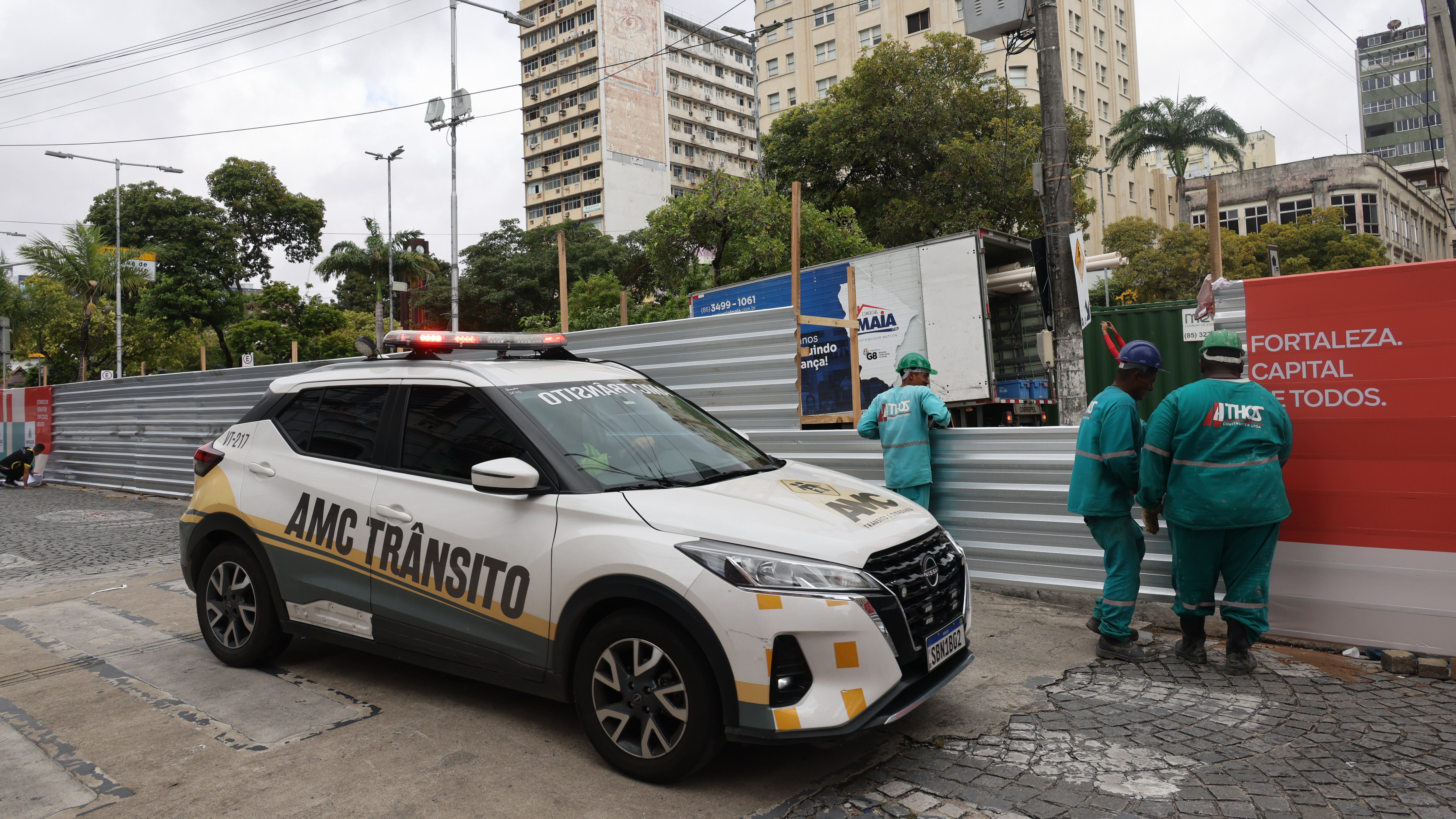 carro da AMC circulando ao lado de operários que colocam tapumes na obra da Praça do Ferreira